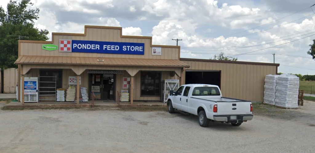 Exterior of Ponder Feed Store building with white pickup truck parked in front
